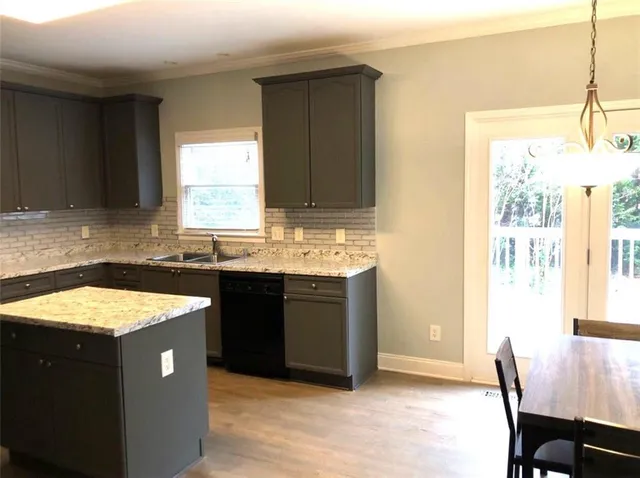 a kitchen with a sink dishwasher a stove a dining table and chairs