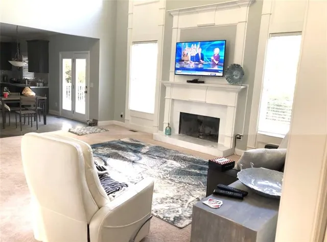 a living room with furniture a fireplace and a flat screen tv