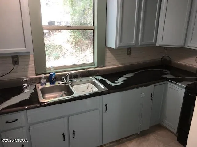 a kitchen with a refrigerator and white cabinets