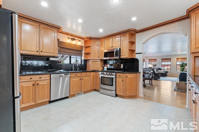 4060 Cimarron Road Fallon, NV 89406 - Photo 7 of 22 a kitchen with granite countertop a stove top oven a sink a counter space and cabinets