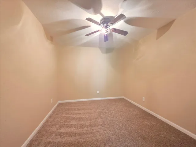 en empty room with windows and fan