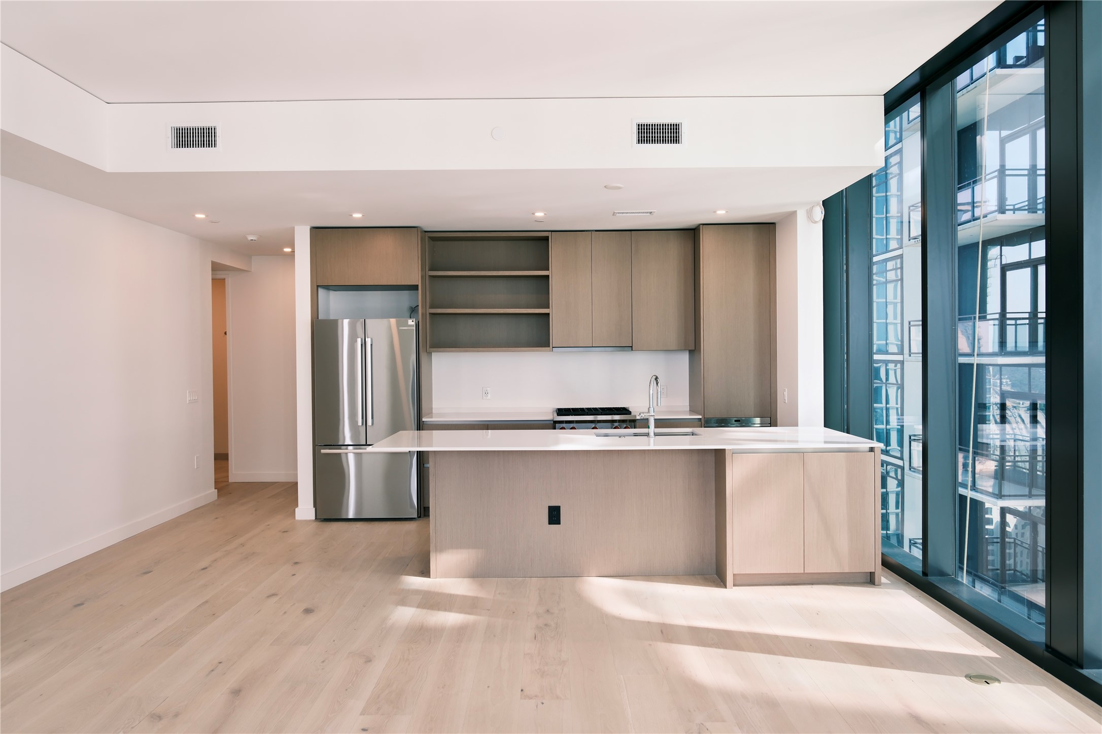 610 Davis Street, Unit 2708 Austin, TX 78701 - Photo 1 of 35 Kitchen featuring open shelves, modern cabinets, freestanding refrigerator, light countertops, and light wood finished floors
