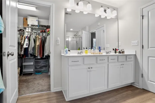 a view of a hallway that has closet with wooden floor