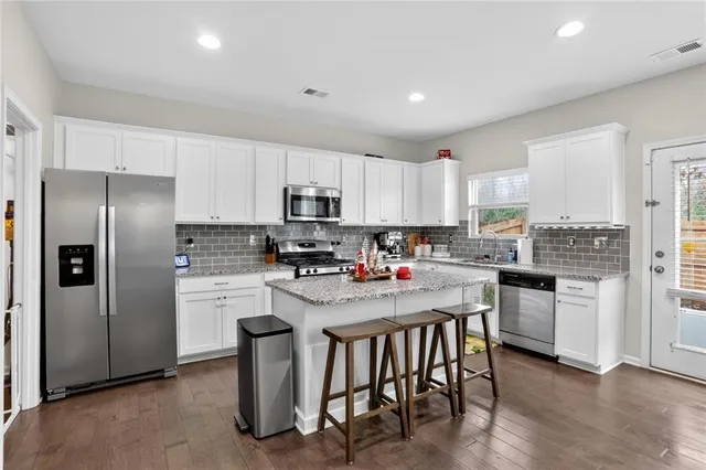 a kitchen with stainless steel appliances granite countertop a refrigerator a stove top oven a sink and dishwasher