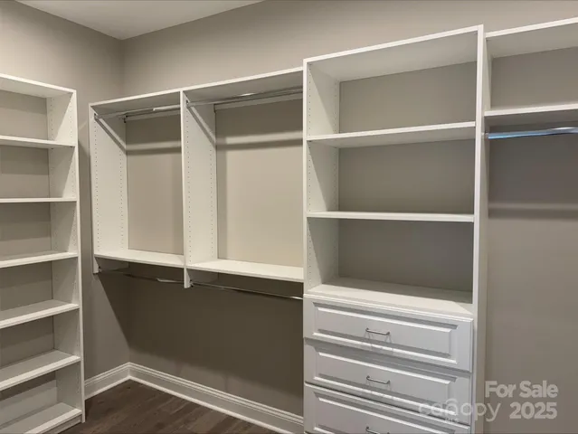 a view of walk in closet with empty racks