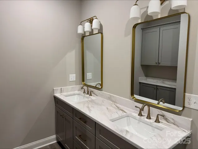 a bathroom with double vanity sinks and a mirror