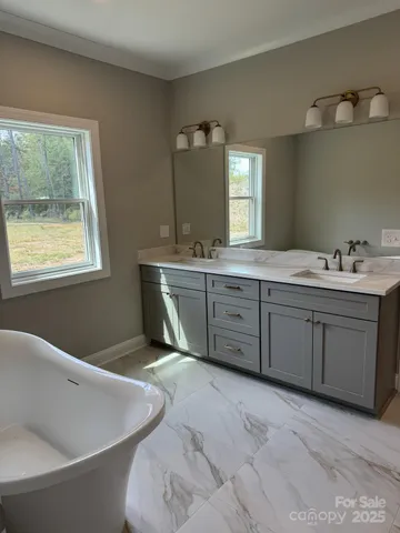a spacious bathroom with a tub sink and mirror