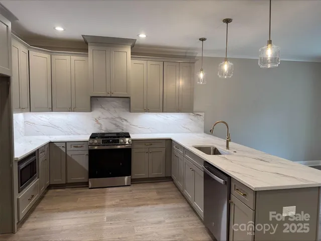 a kitchen with granite countertop a sink and stainless steel appliances