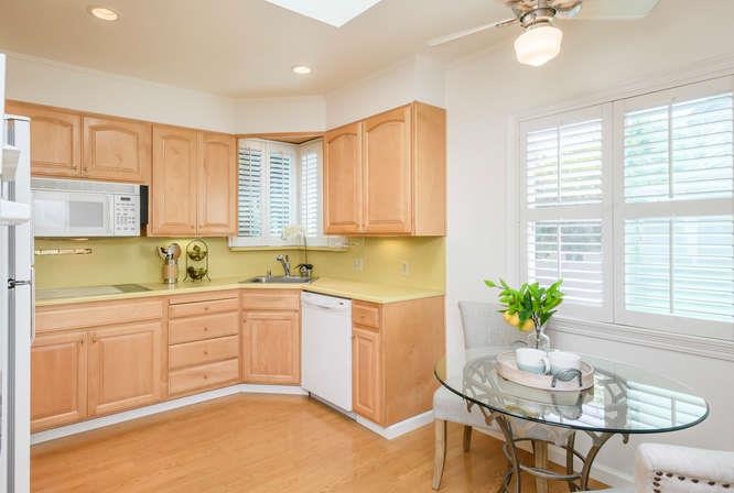 404 Dwight Road Burlingame, CA 94010 - Photo 14 of 33 a kitchen with a refrigerator and white table chairs