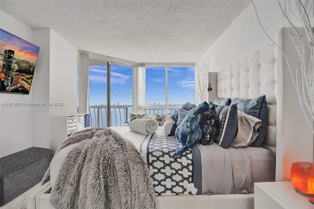 a bedroom with bed and large windows