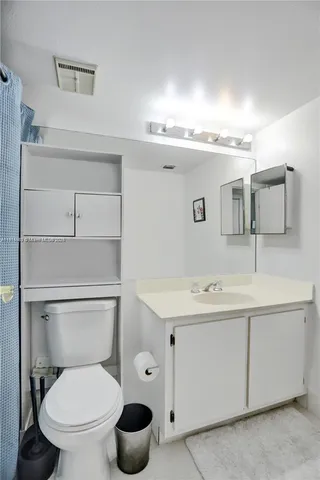 a bathroom with a sink a toilet and mirror