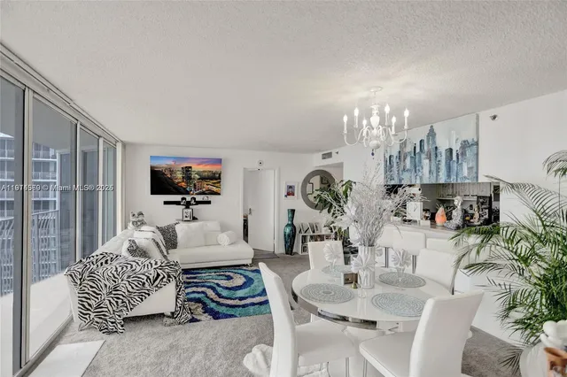 a living room with furniture a chandelier and a dining table