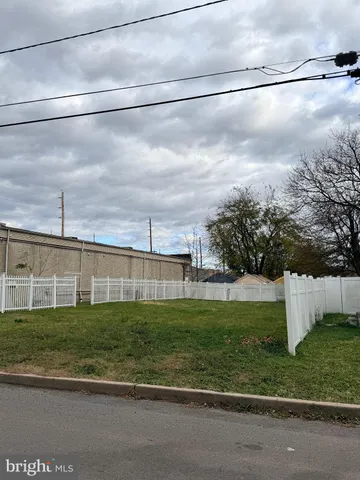 a view of a big building with wooden fence
