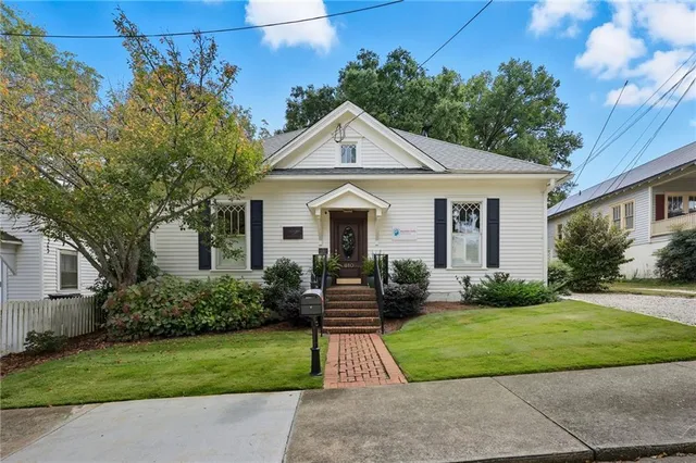a front view of a house with a yard and potted plants