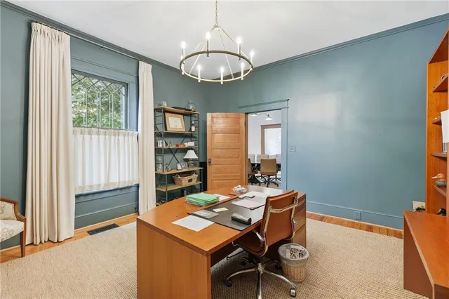 a room with chandelier fan and windows