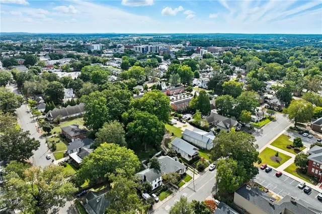 an aerial view of residential houses with outdoor space and trees
