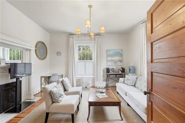 a living room with furniture a fireplace and large windows