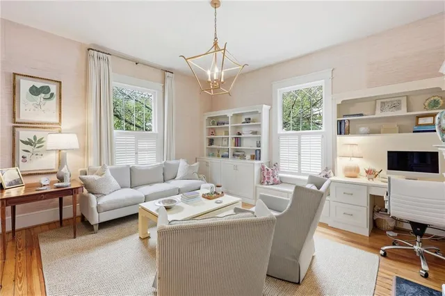 a living room with furniture a large window and a chandelier