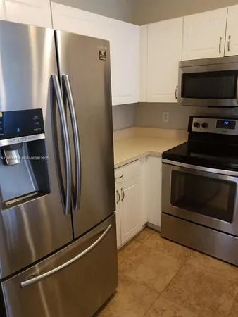 a metallic refrigerator freezer sitting in a kitchen