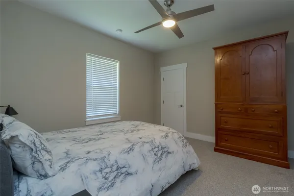 a bedroom with a bed and a ceiling fan