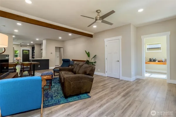 a living room with furniture and a view of kitchen