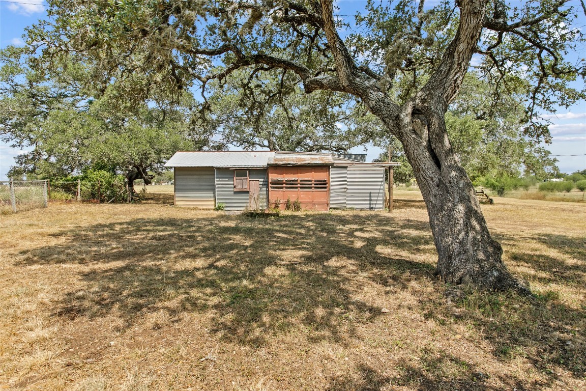 1408 State Park Road Lockhart, TX 78644 - Photo 20 of 38 a backyard of a house with large trees and brick walls