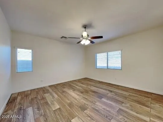 a view of a room with a ceiling fan and hardwood floor