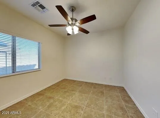 an empty room with a window and a fan