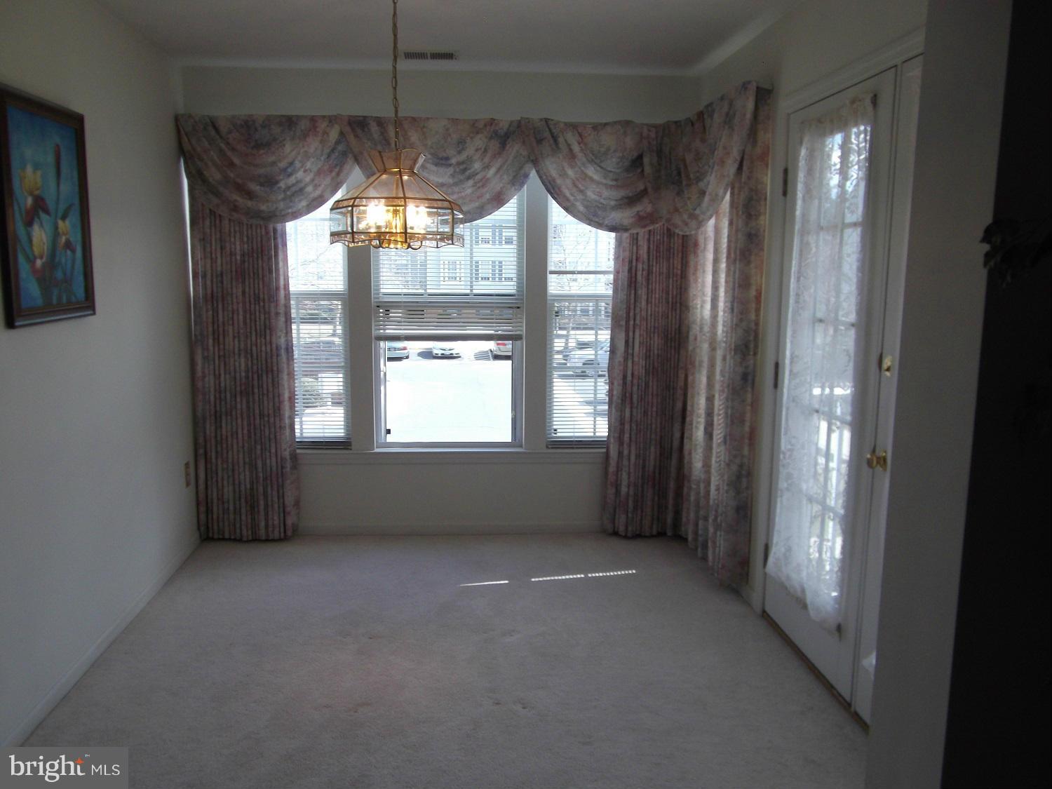 72 Laurel Path Court, Unit 3 Baltimore, MD 21236 - Photo 13 of 18 a view of empty room with window and chandelier