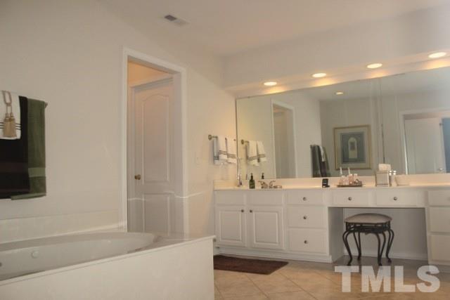 7729 Silver View Lane Raleigh, NC 27613 - Photo 14 of 25 a bathroom with a sink a mirror and a bathtub