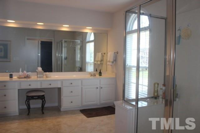 7729 Silver View Lane Raleigh, NC 27613 - Photo 15 of 25 a spacious bathroom with a granite countertop sink and a mirror