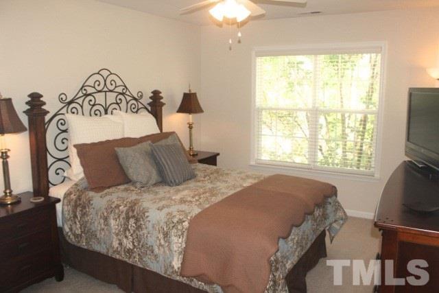 7729 Silver View Lane Raleigh, NC 27613 - Photo 17 of 25 a bedroom with a bed and a flat tv screen on dresser