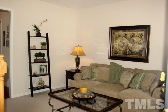 7729 Silver View Lane Raleigh, NC 27613 - Photo 4 of 25 a living room with furniture and a painting on the wall