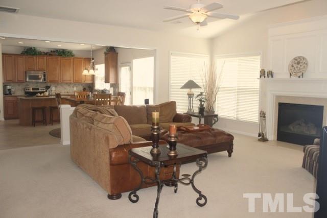 7729 Silver View Lane Raleigh, NC 27613 - Photo 8 of 25 a living room with furniture a fireplace and a large window