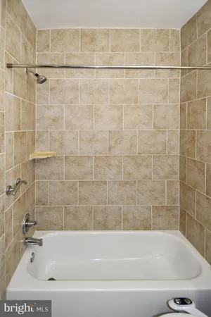 an empty room with wooden floor chandelier fan and windows