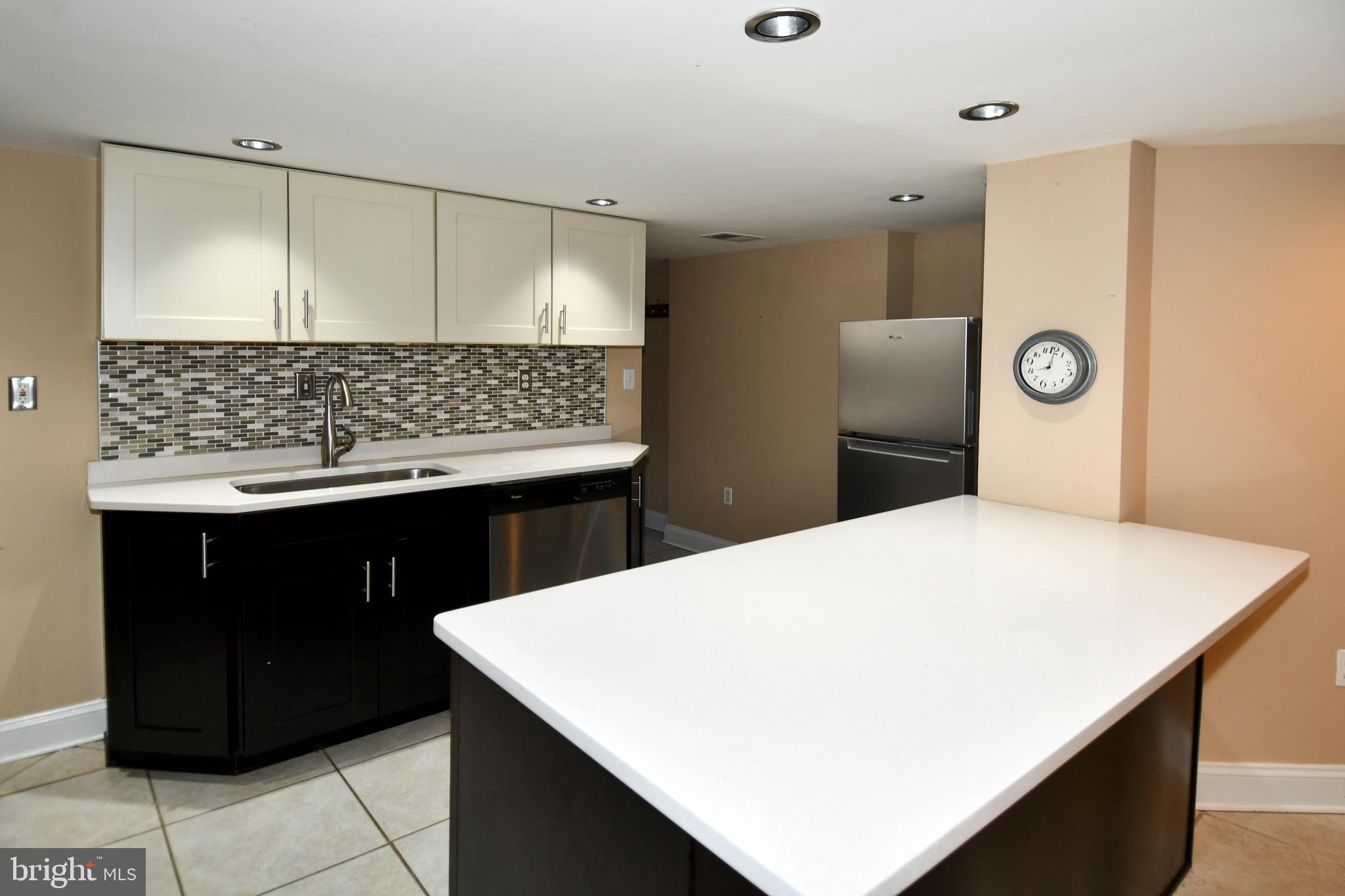 11 R Street Northwest Washington, DC 20001 - Photo 37 of 55 a kitchen with a wooden floor and white cabinets