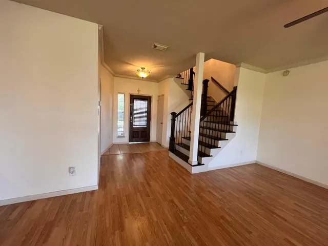 a view of staircase with lots of frames on wall and a window