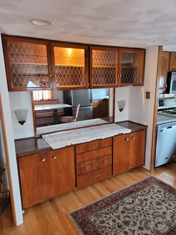 286 Newbury Street, Unit 75 Peabody, MA 01960 - Photo 5 of 18 a kitchen with stainless steel appliances wooden cabinets and a stove