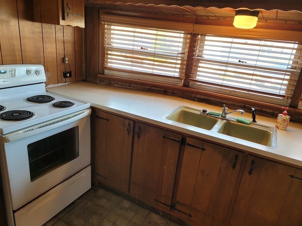 286 Newbury Street, Unit 75 Peabody, MA 01960 - Photo 6 of 18 a kitchen with a stove and a white cabinets