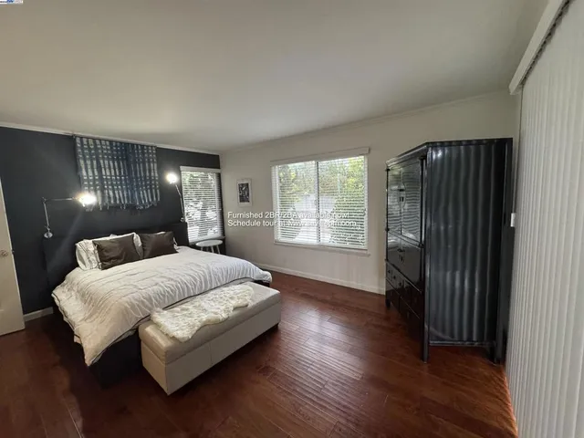 a spacious bedroom with a bed and a lamp with wooden floor