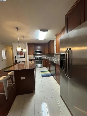 a kitchen with granite countertop stainless steel appliances and a refrigerator