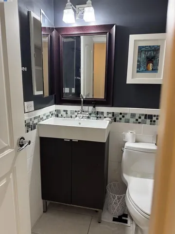 a bathroom with a sink a toilet and mirror