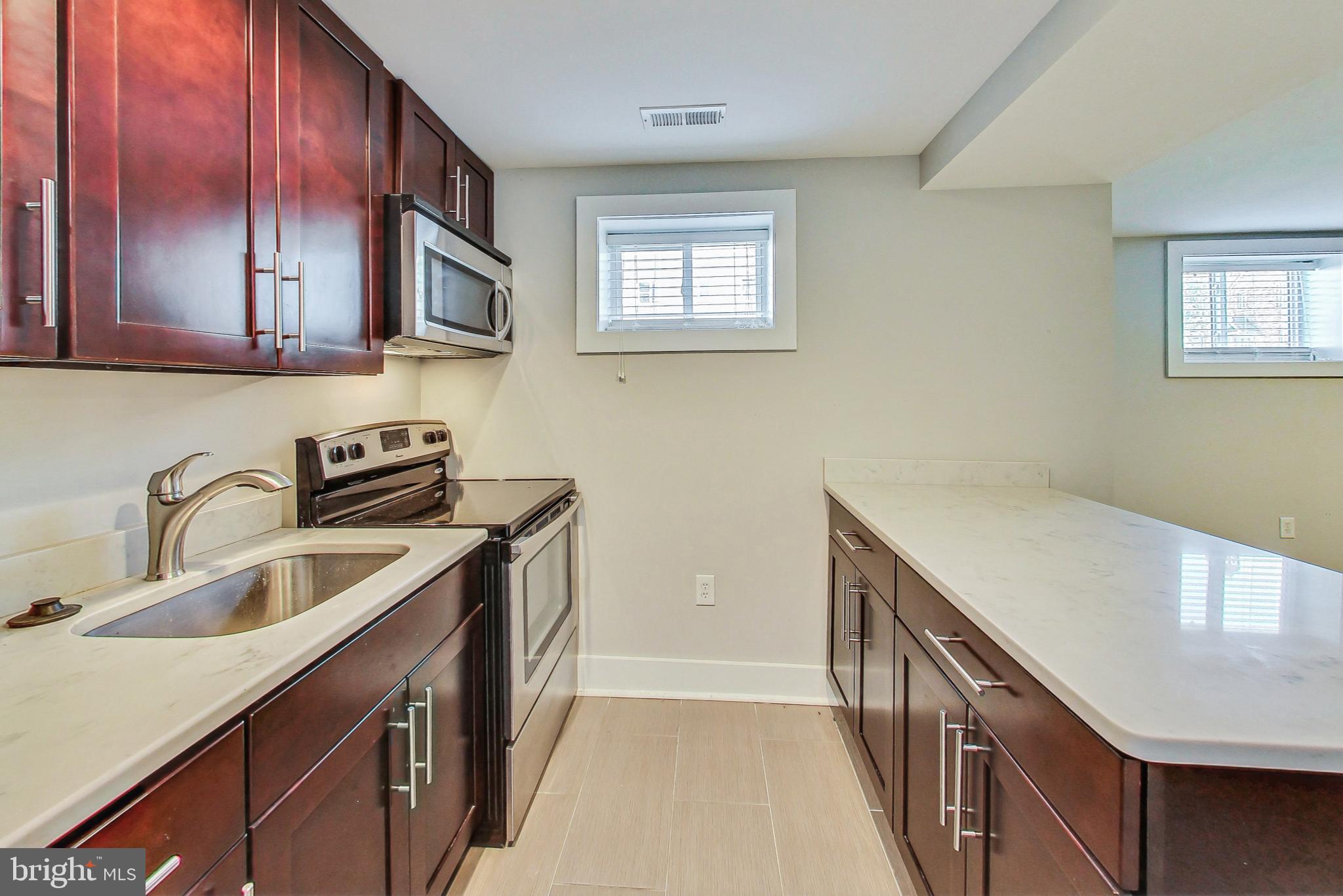 1330 Staples Street Northeast Washington, DC 20002 - Photo 44 of 64 a kitchen with stainless steel appliances granite countertop a sink stove and cabinets