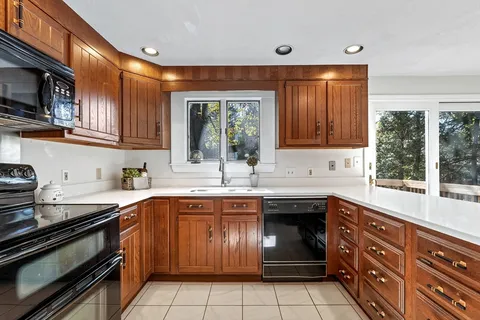 a kitchen with a sink stove top oven and cabinets