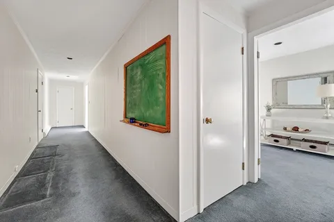 a view of a hallway and a livingroom with furniture