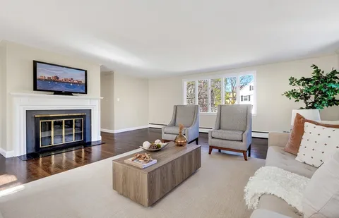 a living room with furniture a fireplace and a large window