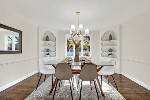a view of a dining room with furniture wooden floor and chandelier