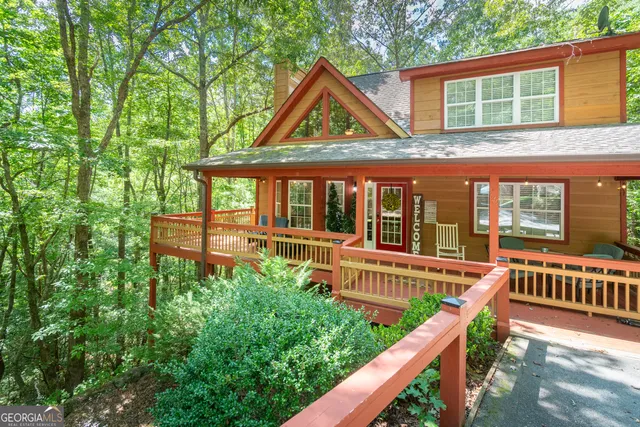 a view of a house with pool and wooden fence