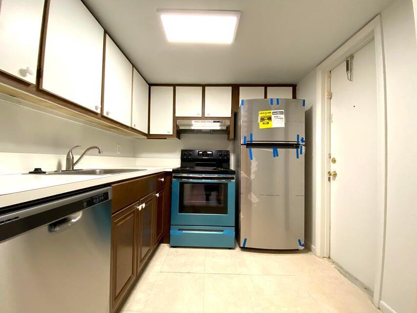 626 Northwest 13th Street, Unit 16 Boca Raton, FL 33486 - Photo 5 of 10 a kitchen with stainless steel appliances a stove a sink and a refrigerator
