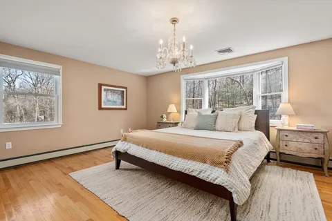 a spacious bedroom with a bed and a chandelier
